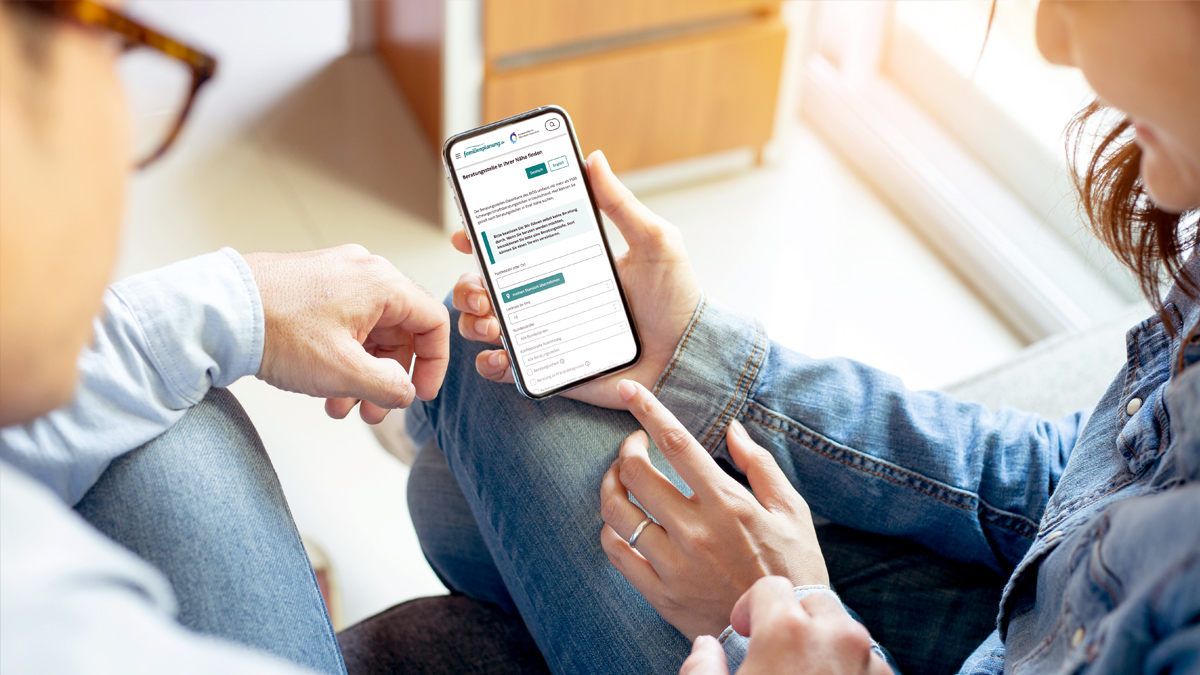 (Quelle: panitan - stock.adobe.com) Paar schaut auf Smartphone nach Beratungsstelle