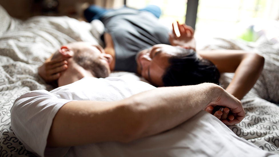 Risikofaktoren für die Fruchtbarkeit (Quelle: SrdjanPav/E+ via Getty Images) Paar liegt im Bett und schaut sich an